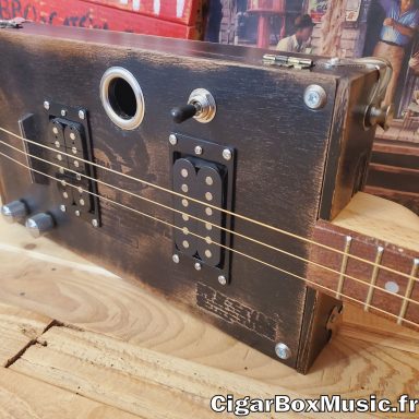 Guitare cigar box électro-acoustique avec double humbucker, switch 3 positions et finition black vintage. Guitare cigar box électro-acoustique avec double humbucker, switch 3 positions et finition black vintage.