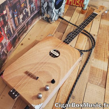 Guitare cigar box acoustique 3 cordes avec ouïe centrale et micro simple bobinage. Boite format Jumbo réalisée à l'atelier. Guitare cigar box acoustique 3 cordes avec ouïe centrale et micro simple bobinage. Boite format Jumbo réalisée à l'atelier.