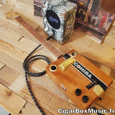 Guitare cigar box électrique accastillage or avec boite importée des Etats-Unis. Réalisée sur commande pour un gaucher. Guitare cigar box électrique accastillage or avec boite importée des Etats-Unis. Réalisée sur commande pour un gaucher.