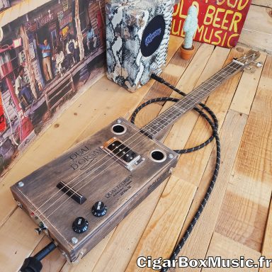 Guitare cigar box électro-acoustique 3 cordes avec micro P90 et finition gris vintage.
