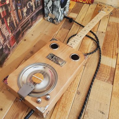 Guitare cigar box acoustique avec résonator et micro humbucker. Boite grand format réalisée à l'atelier. Guitare cigar box acoustique avec résonator et micro humbucker. Boite grand format réalisée à l'atelier.