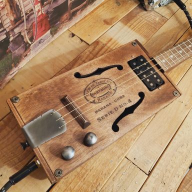 Guitare cigar box acoustique 4 cordes avec une boite Partagas et micro humbucker. Finition vintage.