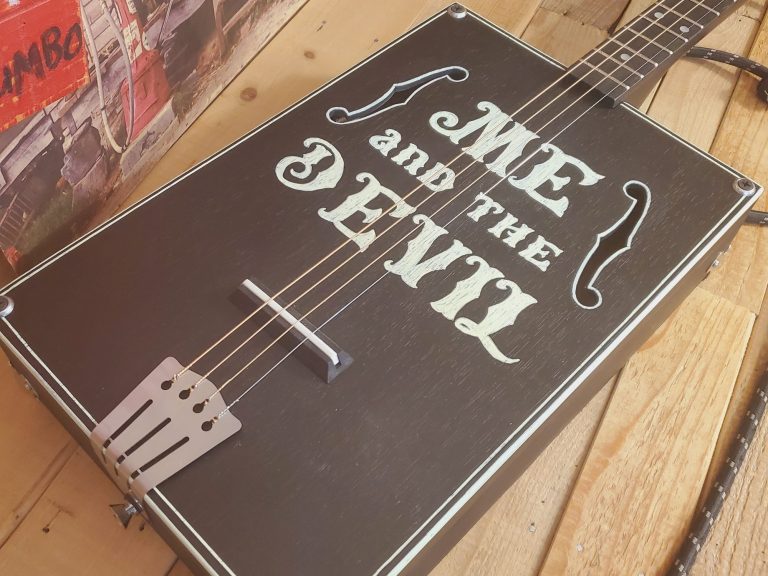 Guitare cigar box noire 4 cordes acoustique look vintage. Guitare cigar box noire 4 cordes acoustique look vintage.