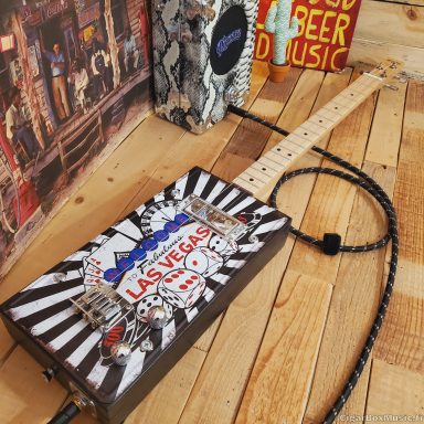 Guitare cigar box électrique noire et blanche réalisée avec une plaque américaine Las Vegas.
