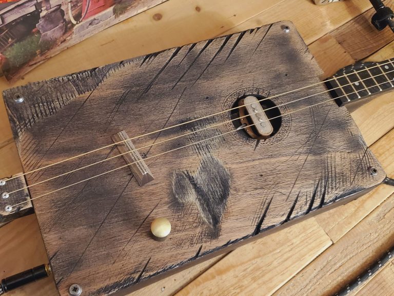 Cigar box guitar 3 cordes grise avec look vintage et usé. Cigar box guitar 3 cordes grise avec look vintage et usé.