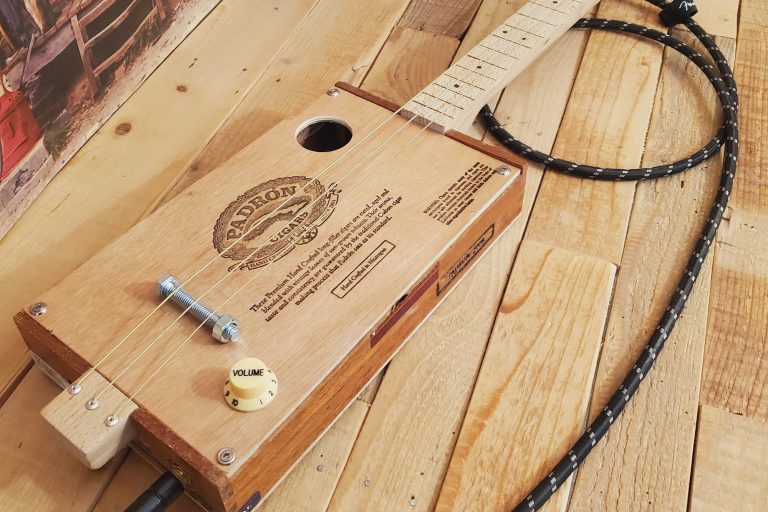 Guitare cigar box 3 cordes fretless avec une boite de cigares Padron. Guitare cigar box 3 cordes fretless avec une boite de cigares Padron.