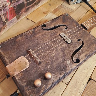 Guitare cigar box acoustique 3 cordes avec micro simple bobinage et accastillage bronze. Finition vintage. Guitare cigar box acoustique 3 cordes avec micro simple bobinage et accastillage bronze. Finition vintage.