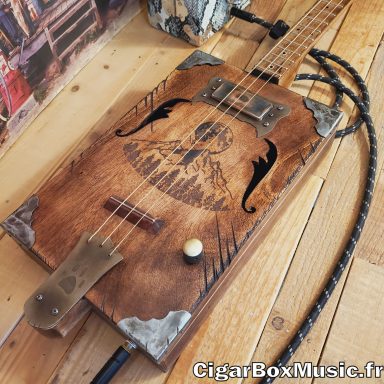 Guitare cigar box acoustique 3 cordes avec humbucker. Accastillage et boite grand format réalisés à l'atelier. Finition vintage. Guitare cigar box acoustique 3 cordes avec humbucker. Accastillage et boite grand format réalisés à l'atelier. Finition vintage.